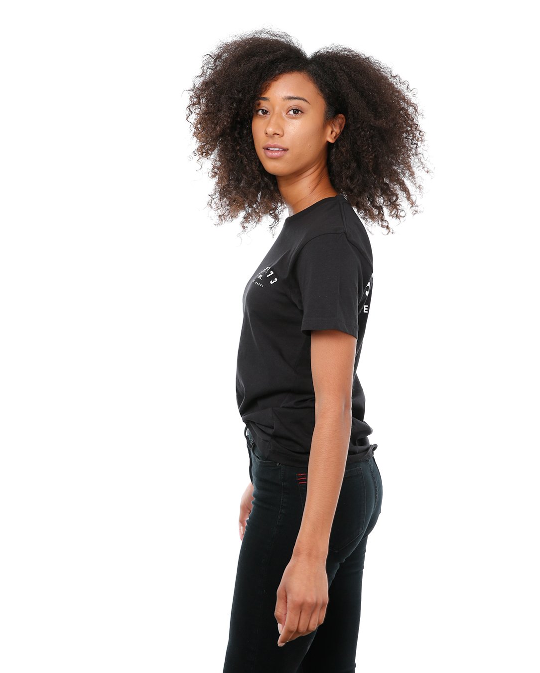 Side view of female model in Black Classic Short Sleeve T-Shirt on white background.