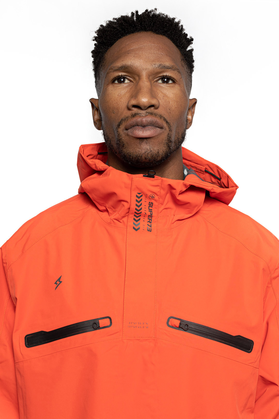 Detail shot of Male model wearing Vale Packable Anorak in blood orange colorway.