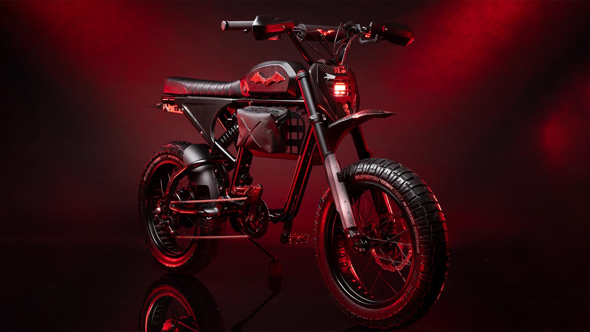 Front view of the custom Super73 Batman bike on a red background.