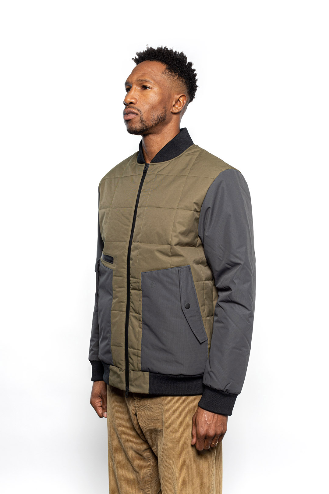 Side view of Male model wearing Sipes Varsity Jacket in dark fatigue colorway.
