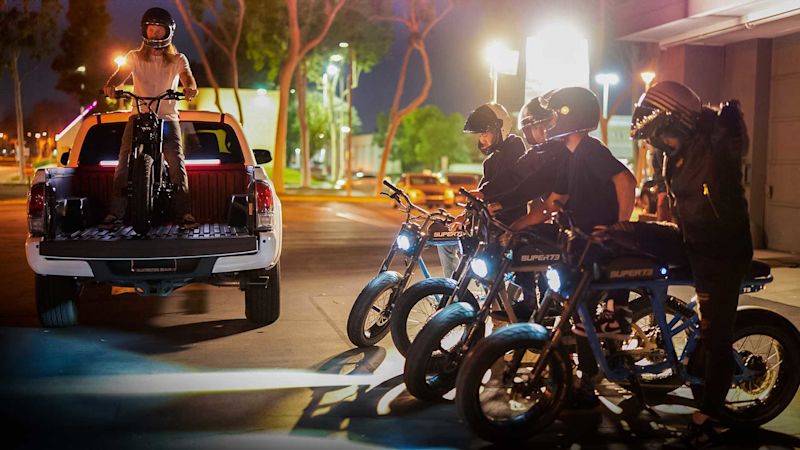Super73 ColorwaySlider R 1920x1080 01 A group of friends on bikes in different colors hanging out in a parking lot