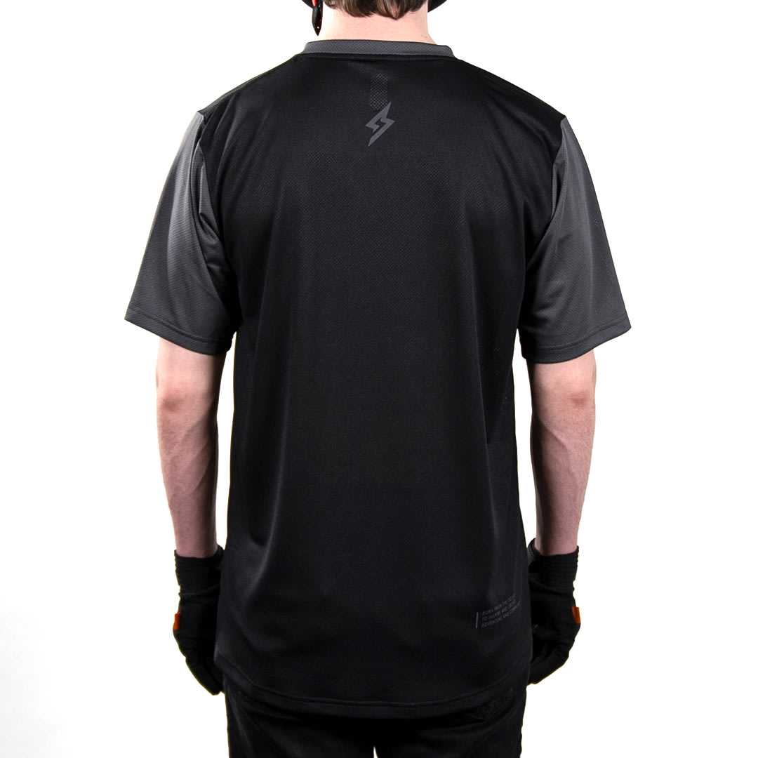 Back view of male model wearing 100% x Super73 Ridecamp short sleeve Jersey.
