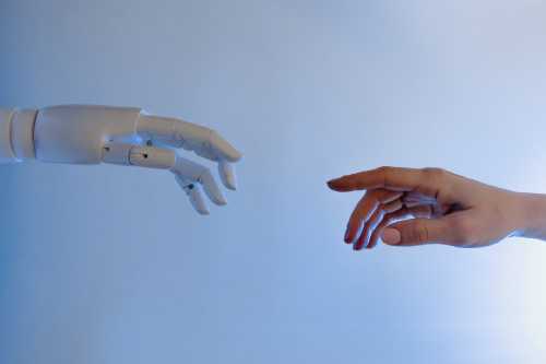 chatGPT AI robot hand touching human software developers hand