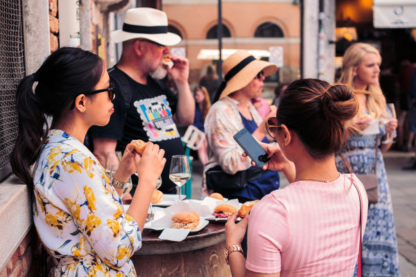 A quick bite and a glass of wine on the street as a Venetian tradition. 