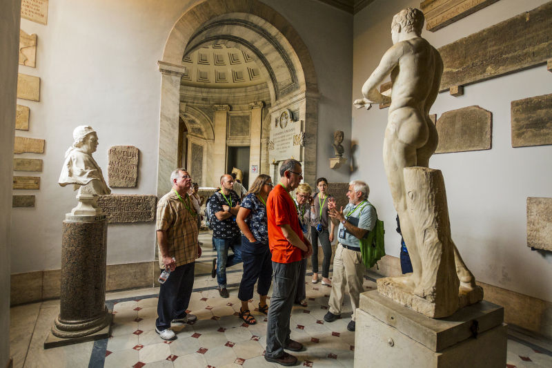 A small group of tourists explores the Vatican Museums.