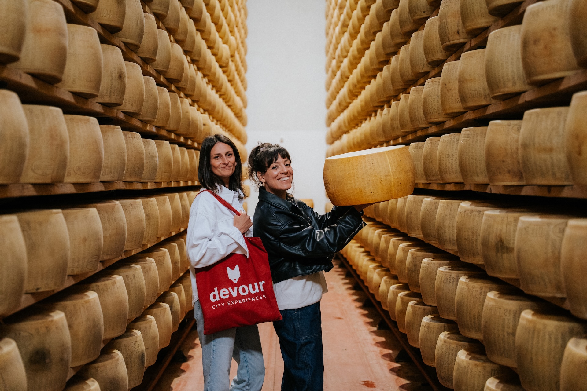 Posing with a wheel of parmesan at a factory in the outskirts of Bologna