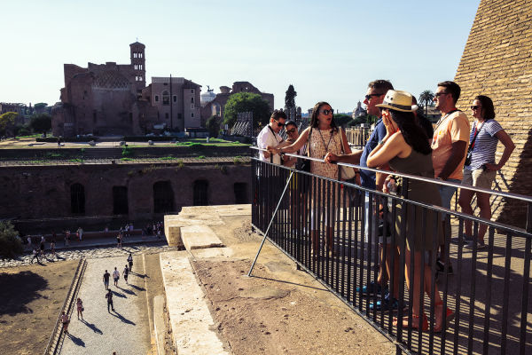 A guide shows people views over the Roman forum from the 3rd tier of the Colosseum