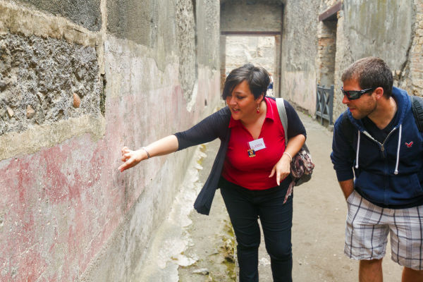 An expert guide shows off a fresco that is around 2,000 years old