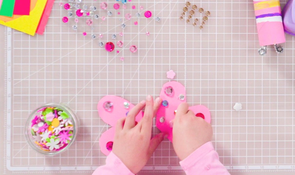 Young girl's hands making butterly wings with paper