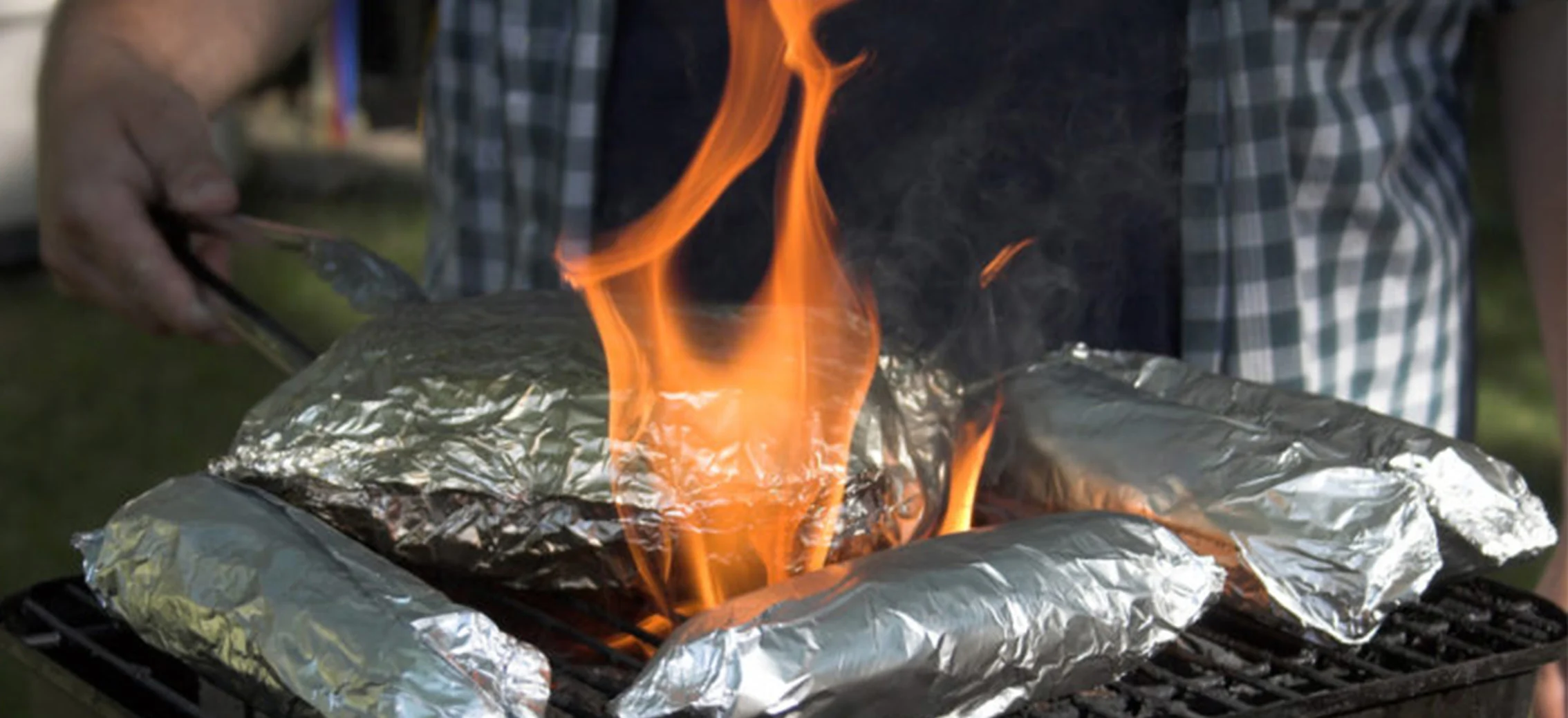Un hombre asando barbacoa en una parrilla