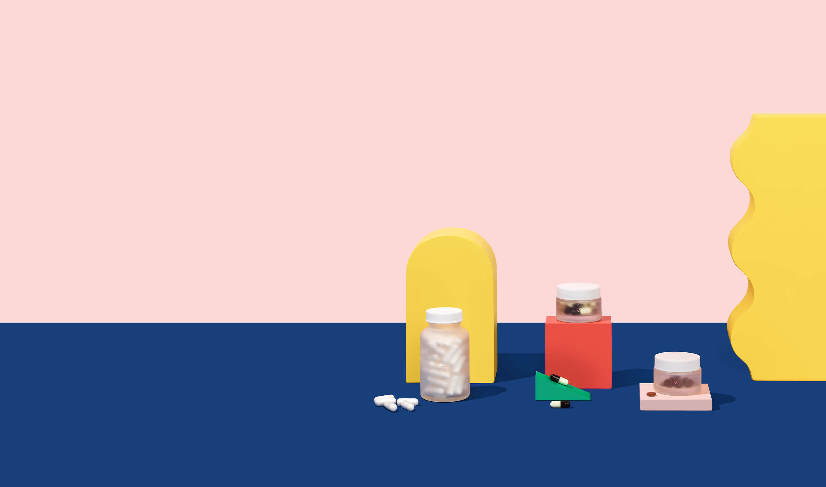 Pill bottles balanced on geometric shapes.