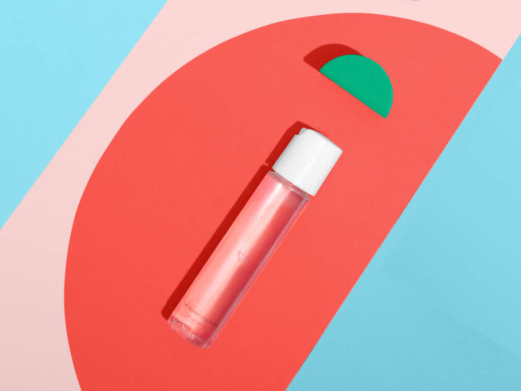 bottle of harmonizing lube against background of colorful shapes
