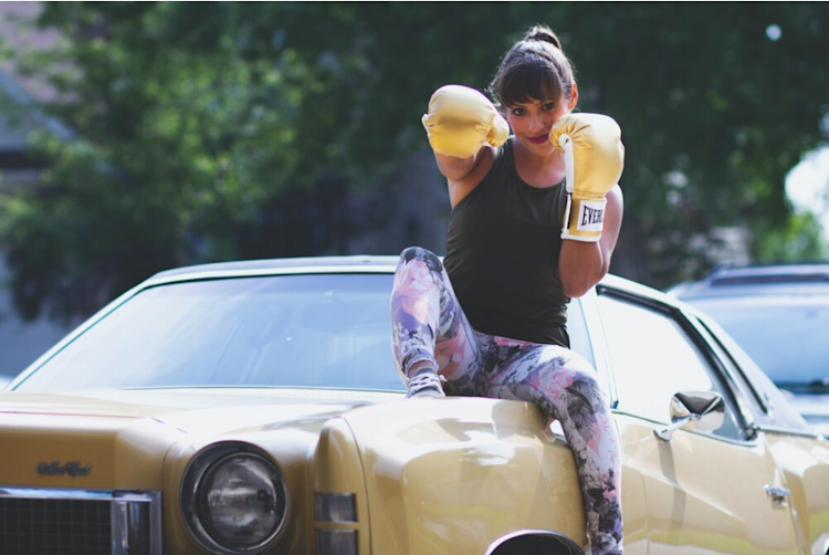 woman sitting on car punching