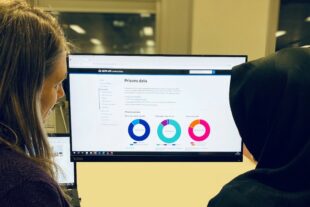 Decorative image of two people looking at a screen with text and doughnut charts