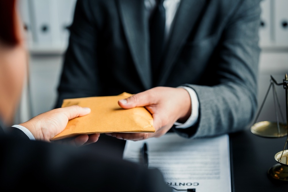 client handing lawyer an envelope of money