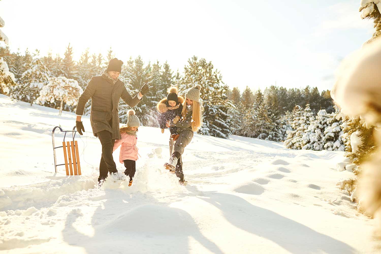 Verspieltes Paar mit Kindern im Winterwald