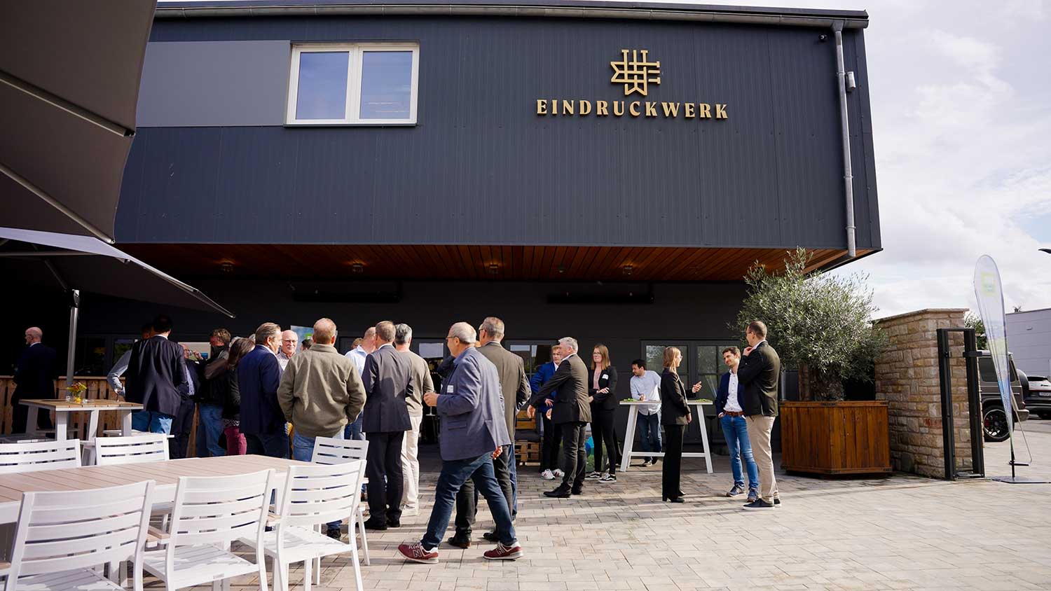 Gäste des Sommerfestes stehen in dem Hof von dem Eindruckwerk in Monsheim.