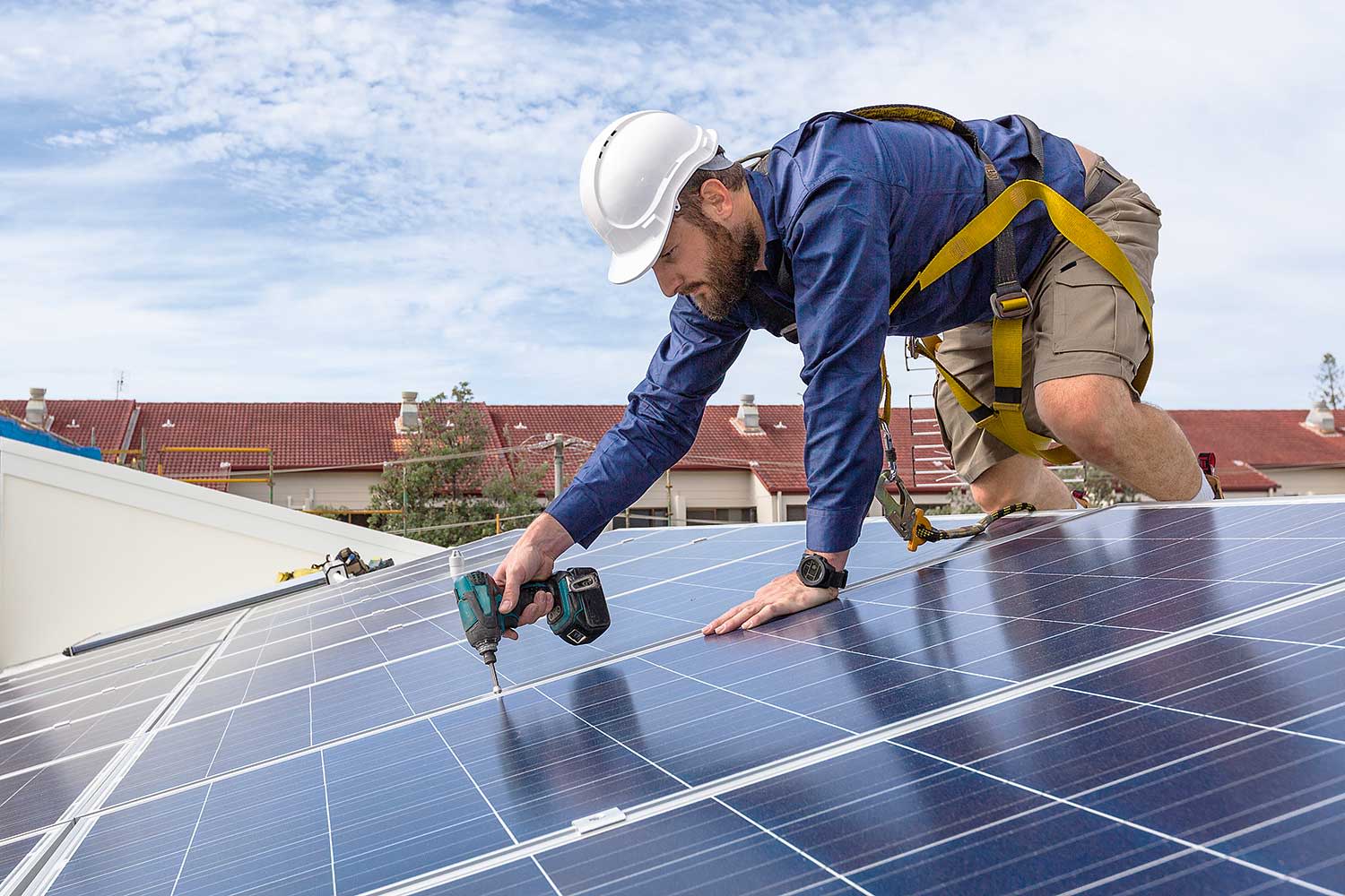 Handwerker montiert Photovoltaikanlage auf dem Dach