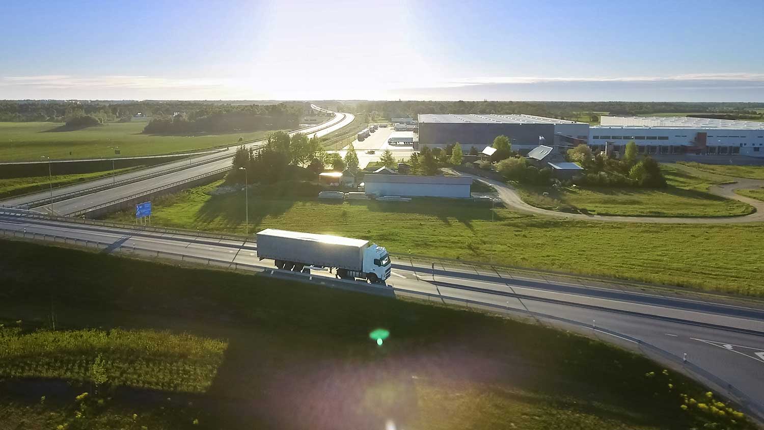 Luftaufnahme eines weißen LKW mit Lager im Hintergrund