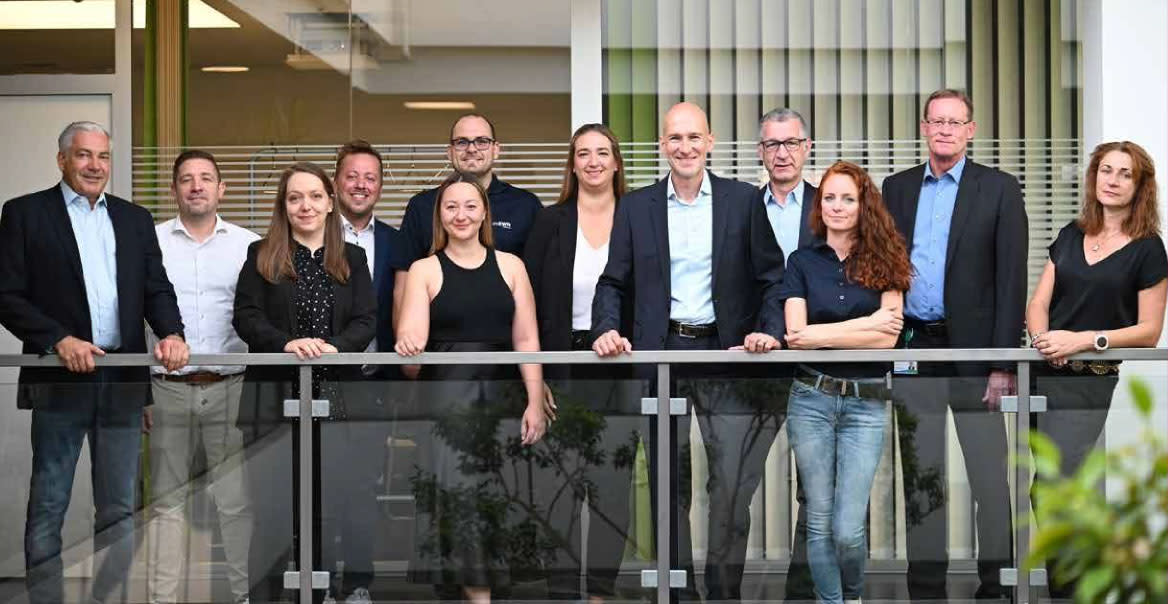 Personen stehen vor einem Geländer