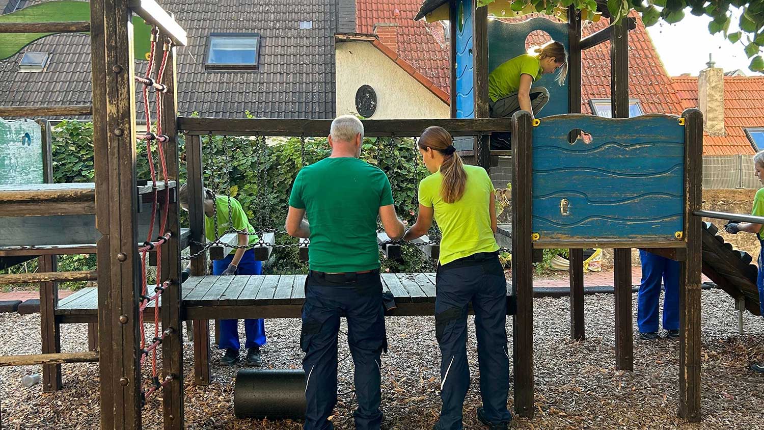 EWR Mitarbeiter erneuern ein Klettergerüst im Kindergarten