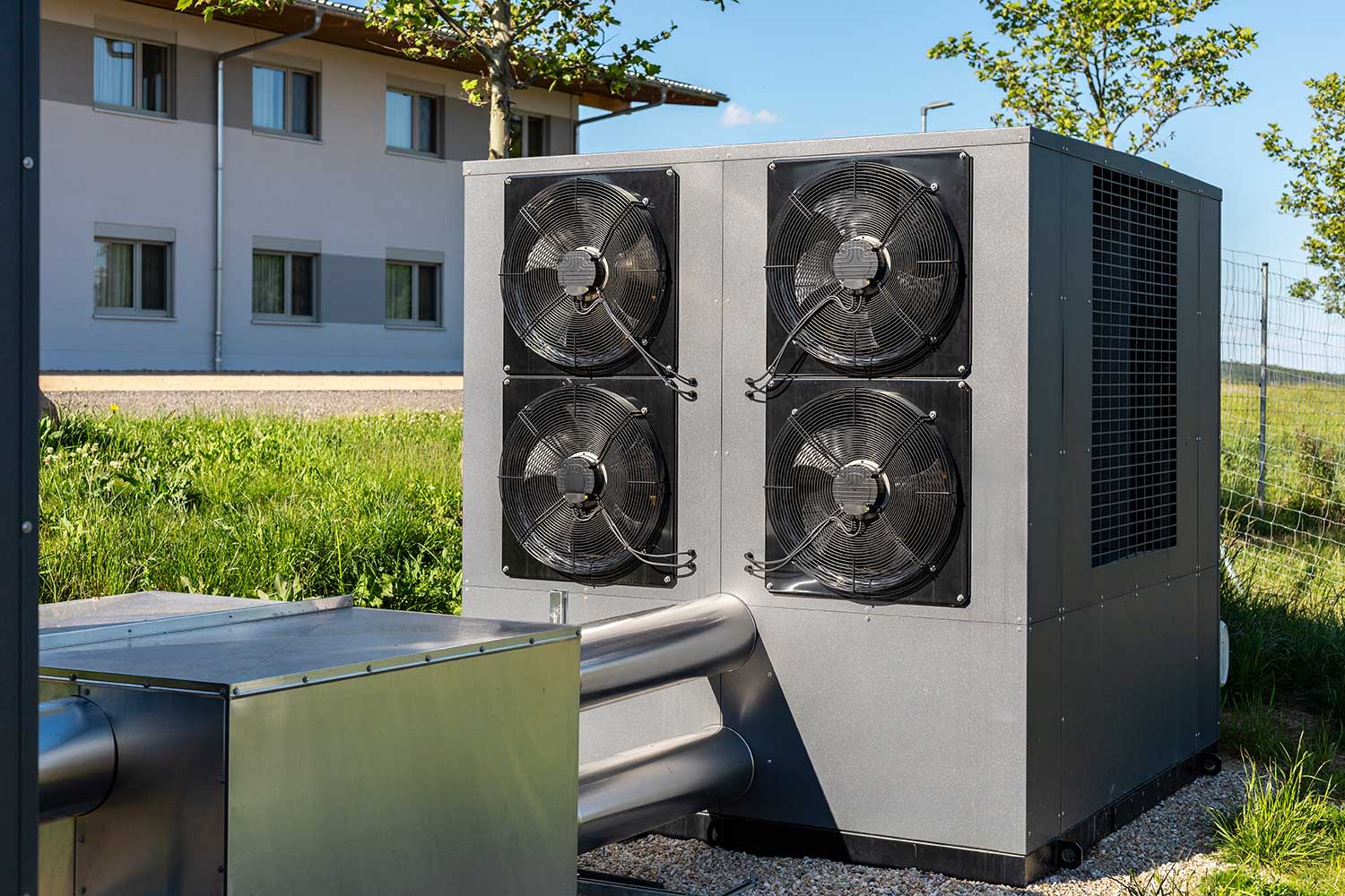 Wärmepumpe steht vor Gebäude.