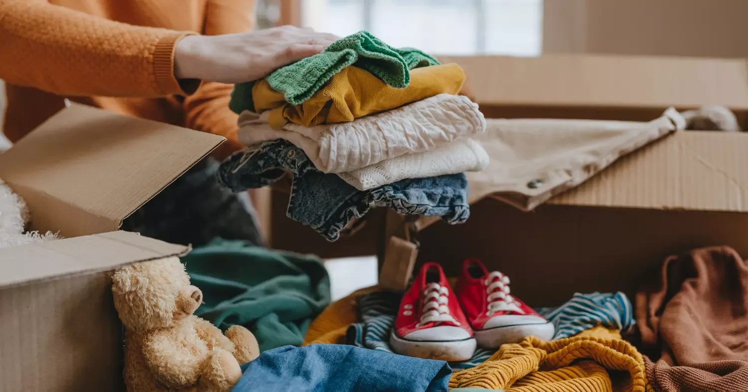 Frau sortiert ein altes, nicht mehr benutztes Kinderspielzeug