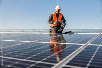 Foto von einem Handwerker auf Solarmodulen