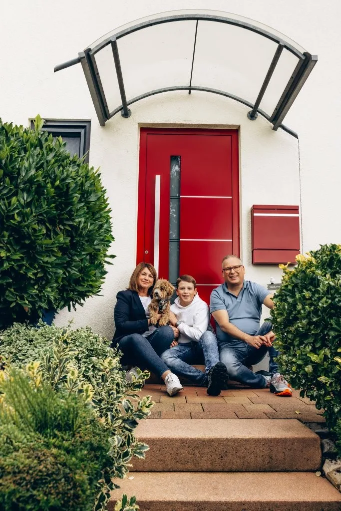 Familie Hieronymus sitzen auf der Treppe vor ihrem Haus Familie Hieronymus sitzen auf der Treppe vor ihrem Haus