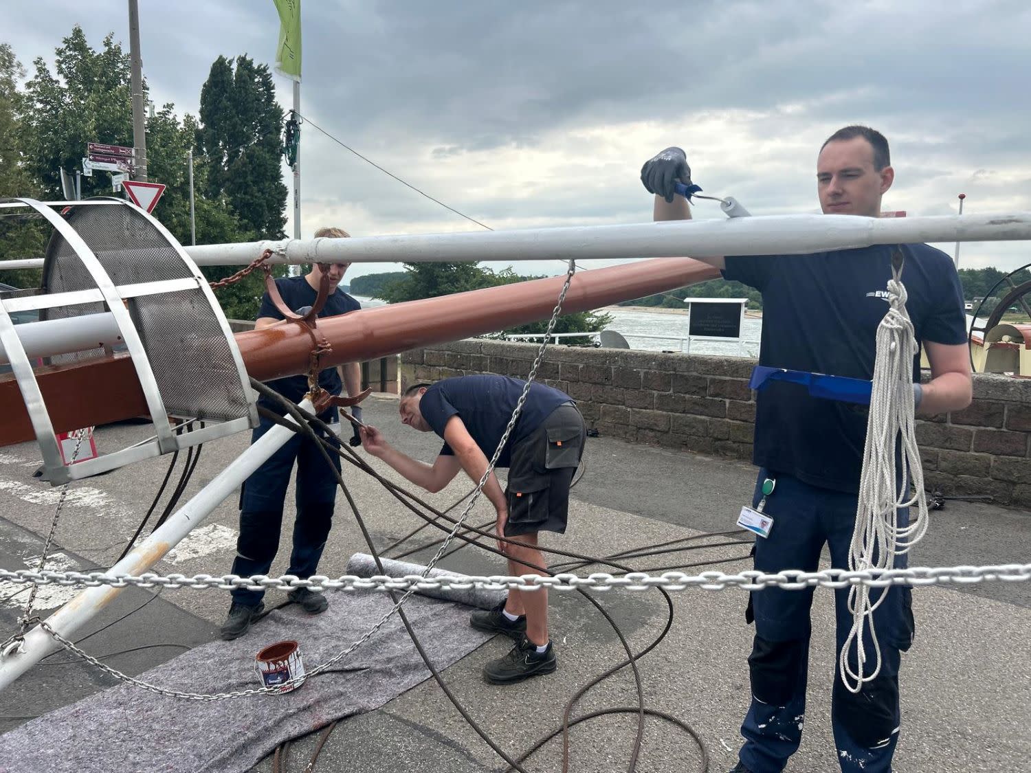 Personen streichen einen Schiffsmast