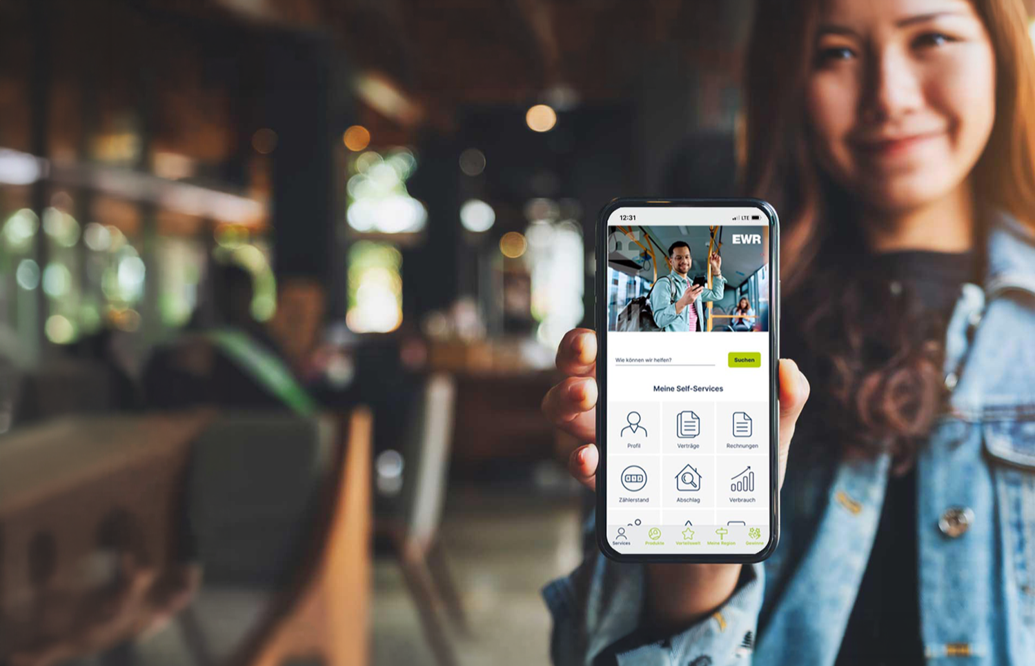 Eine Frau hält ein Handy in der Hand. Auf dem Handy ist der Startscreen der EWR Connect App zu sehen