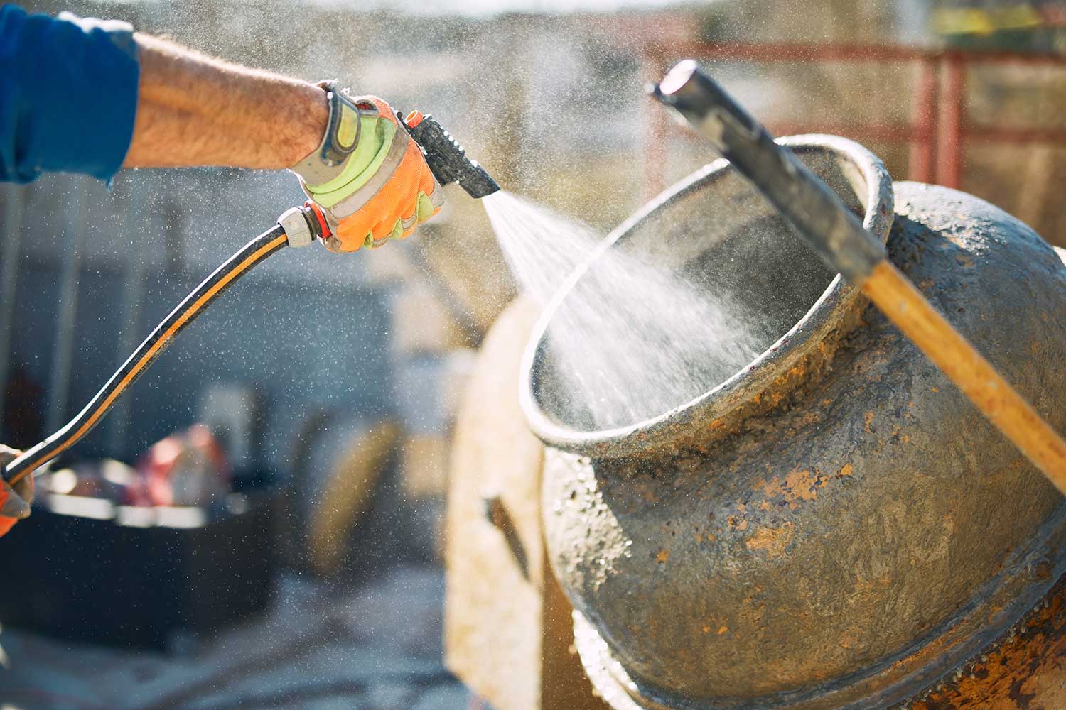 Betonmaschine wird mit Wasserschlauch gereinigt