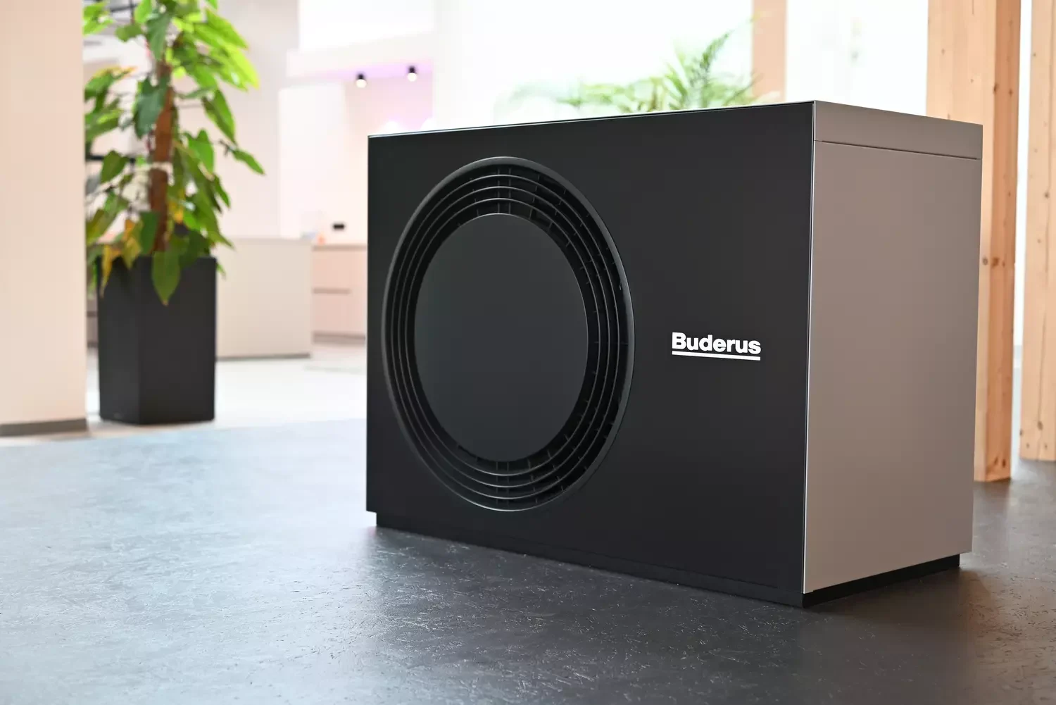 Buderus Wärmepumpe steht im Vordergrund mit Pflanze im Hintergrund
