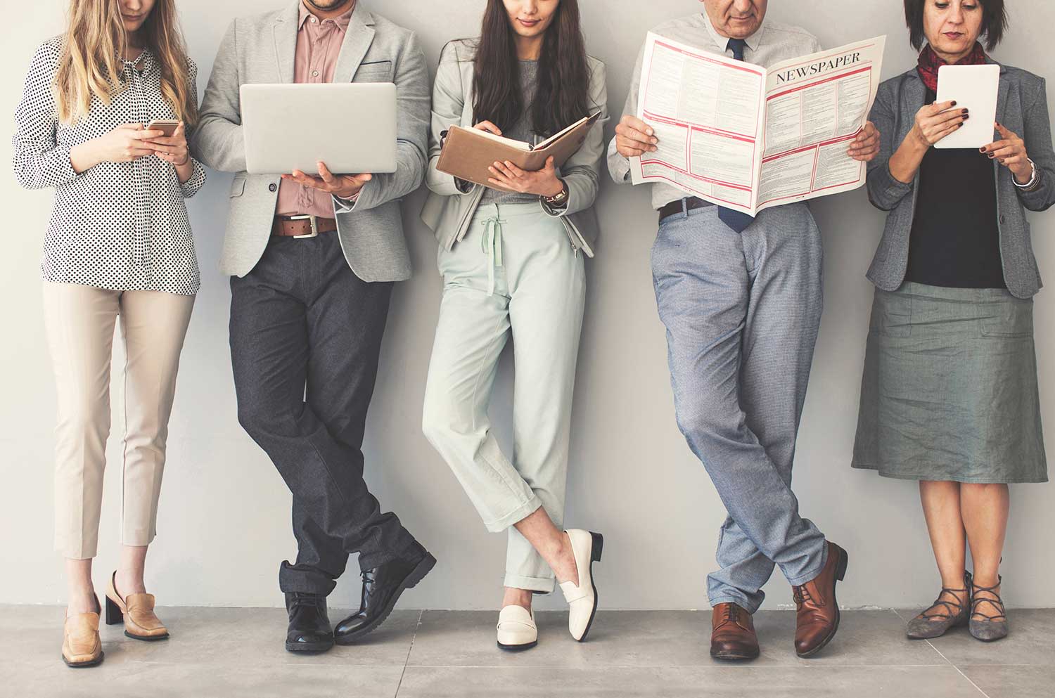 Eine Gruppe Personen schaut in diverse Medien