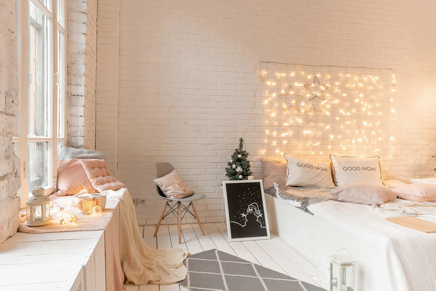 alt = 'Bett im Schlafzimmer mit Kerzen und Weihnachtsbaum