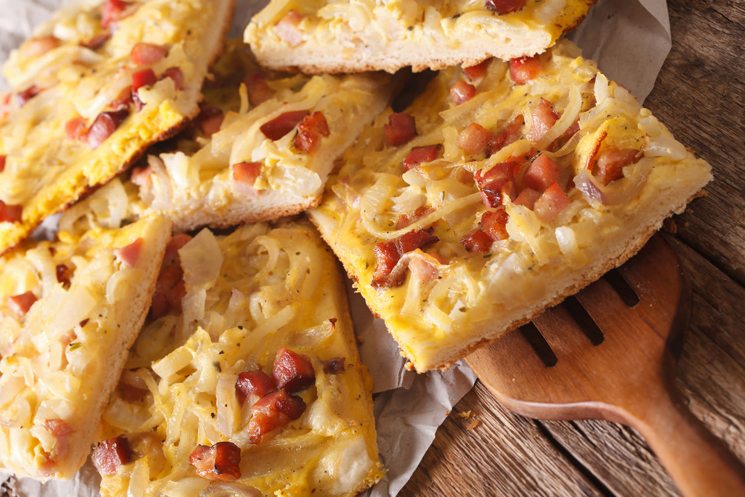 Zwiebelkuchen-mit-Schinkenspeck-auf-Holztisch Zwiebelkuchen-mit-Schinkenspeck-auf-Holztisch