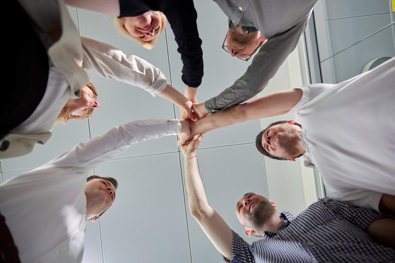 Sechs Mitarbeiter geben sich high five