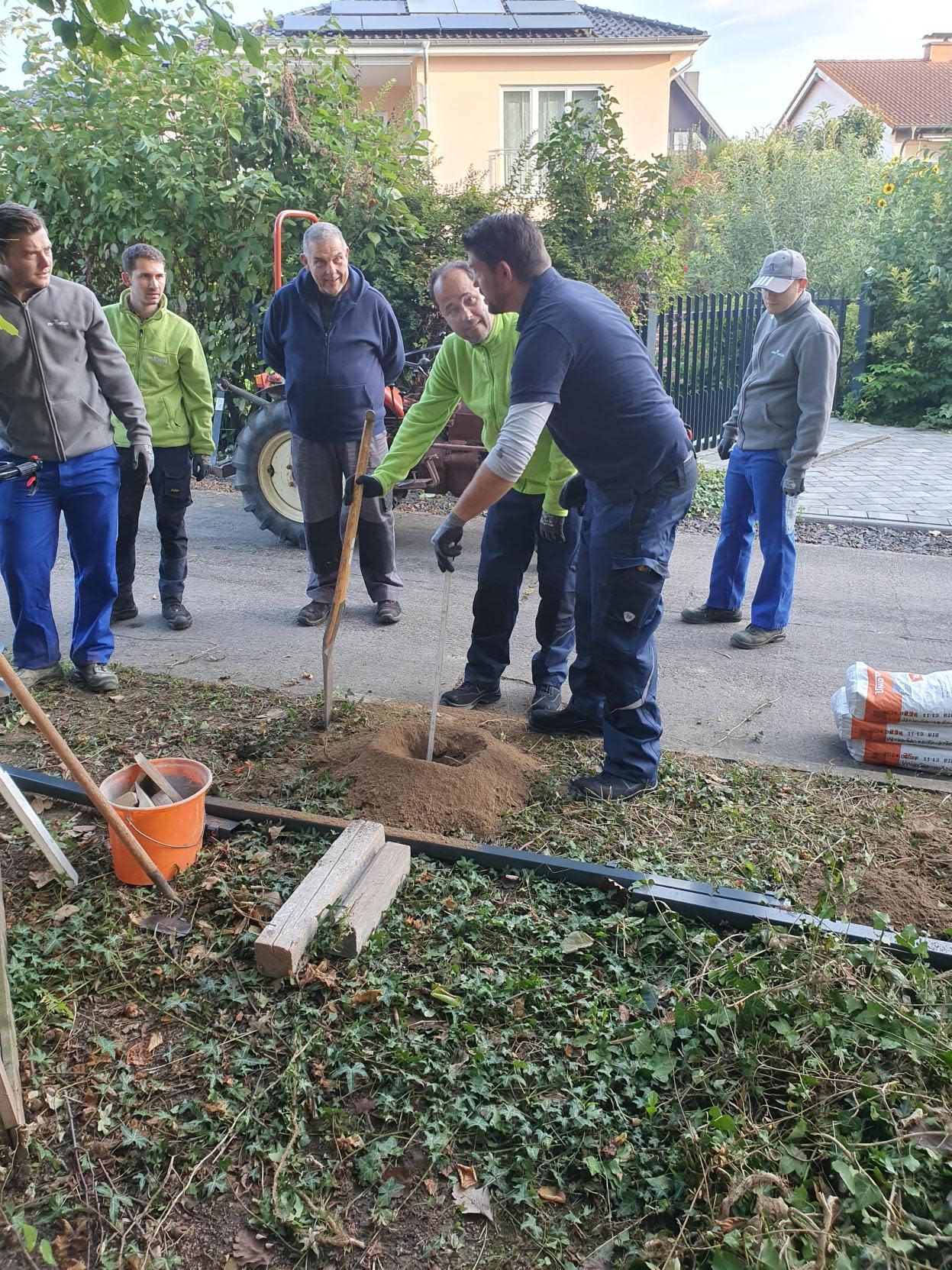Helfer beim ausmessen der Lochbohrungen für den Zaun