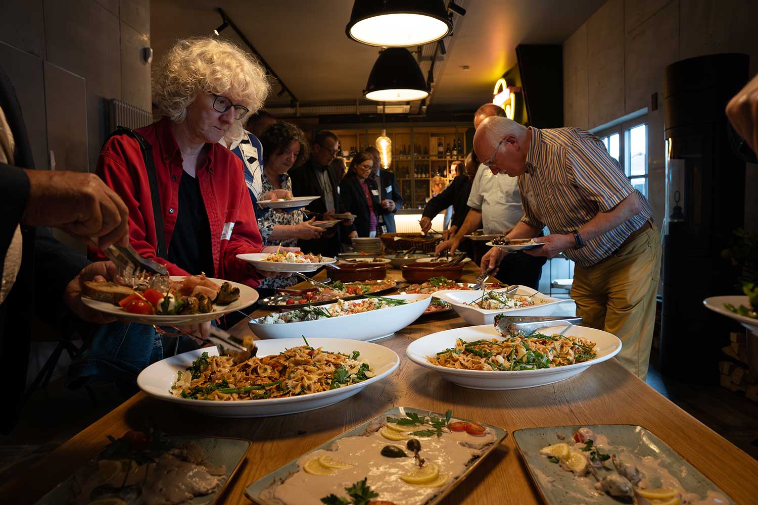 Teilnehmer bedienen sich an dem Buffet.