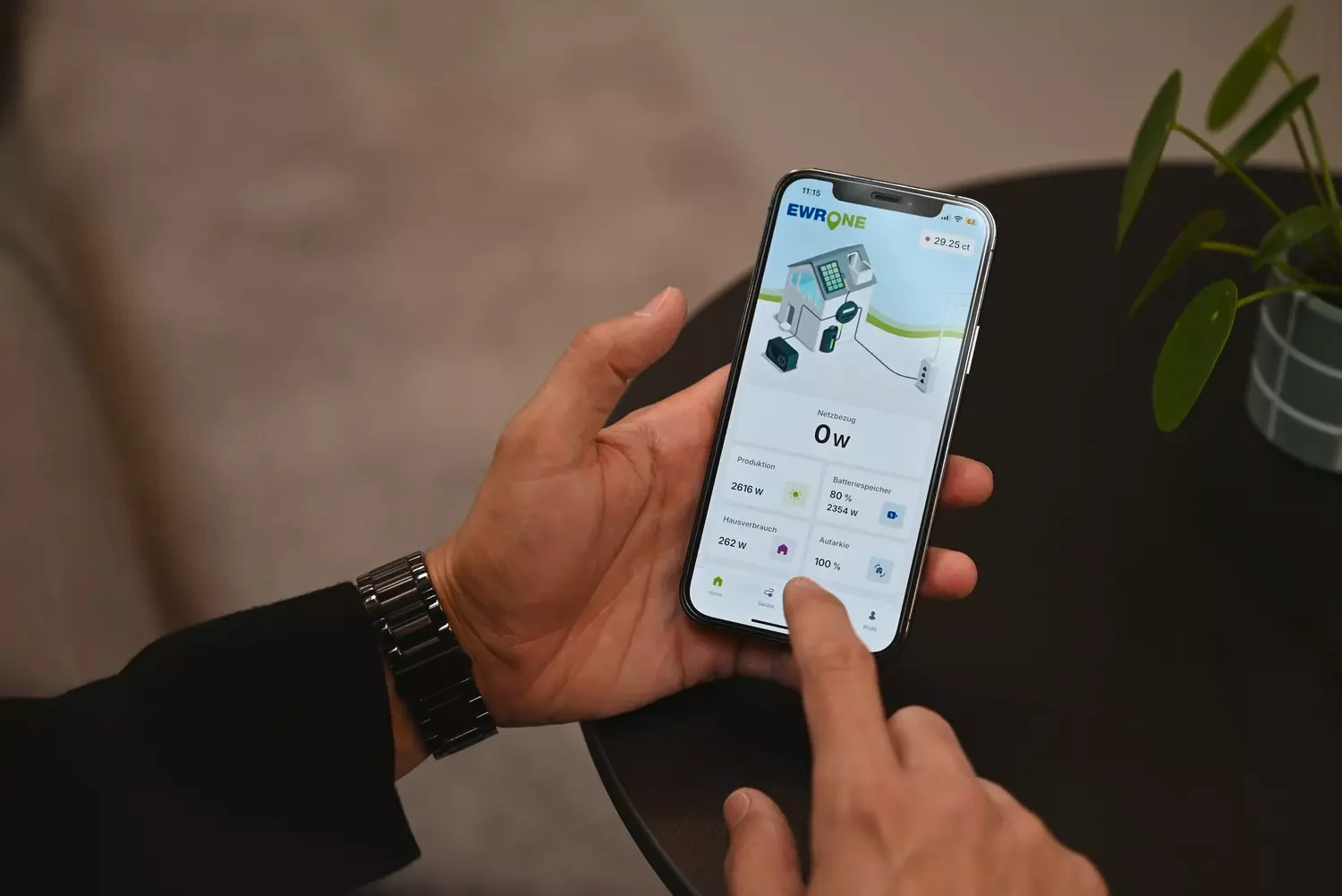 Männliche Hände mit Handy und dem EWR One Manager darauf.