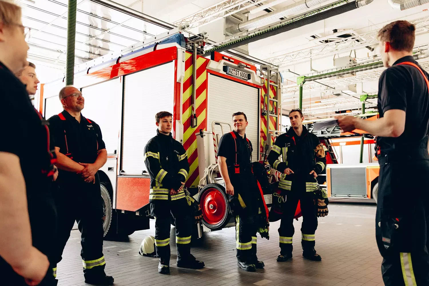 Feuerwehrmänner stehen in einer Feuerwache zusammen