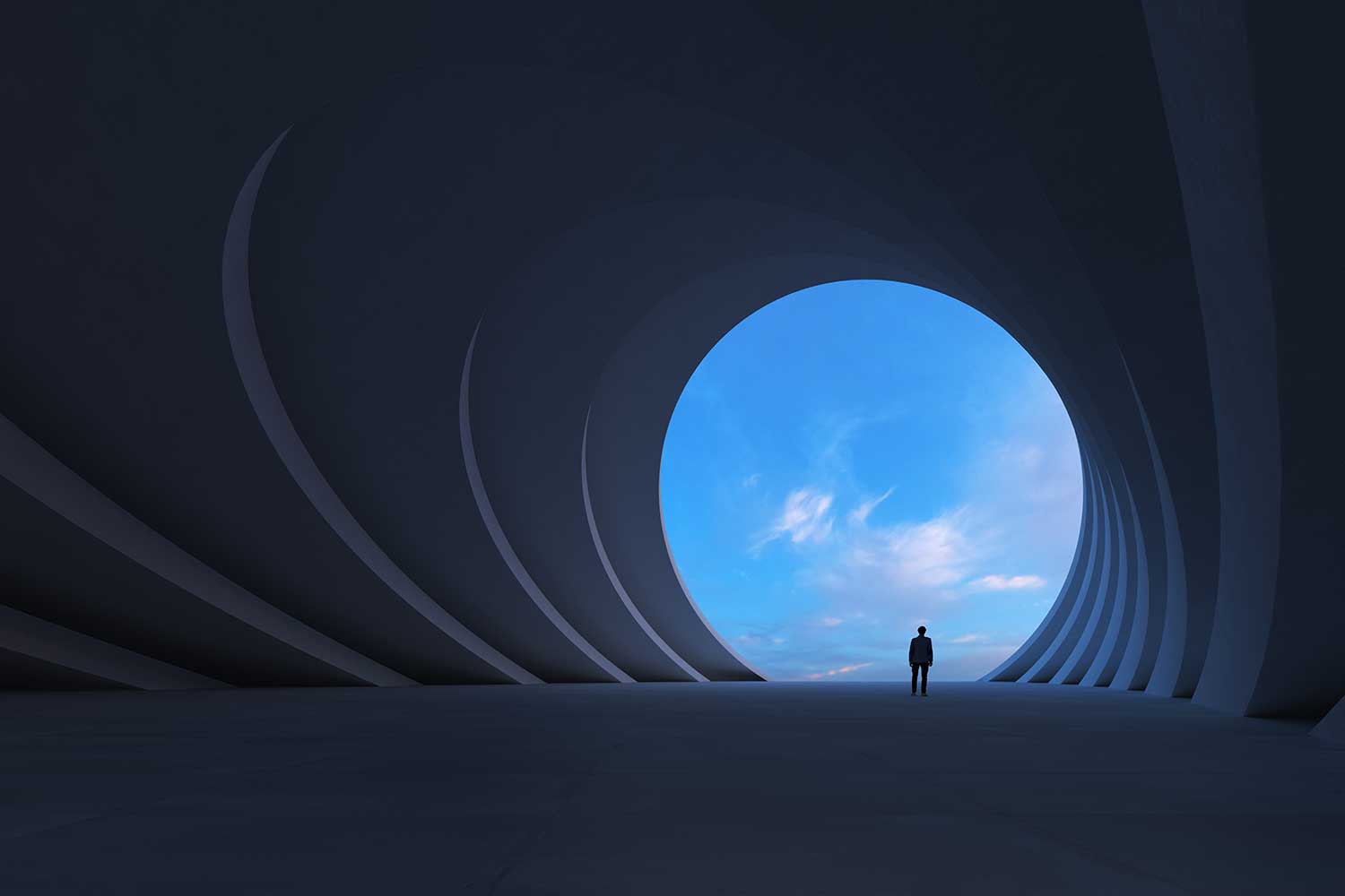 Ein Mensch steht am Ende/Ausgang eines Tunnel zum Freien