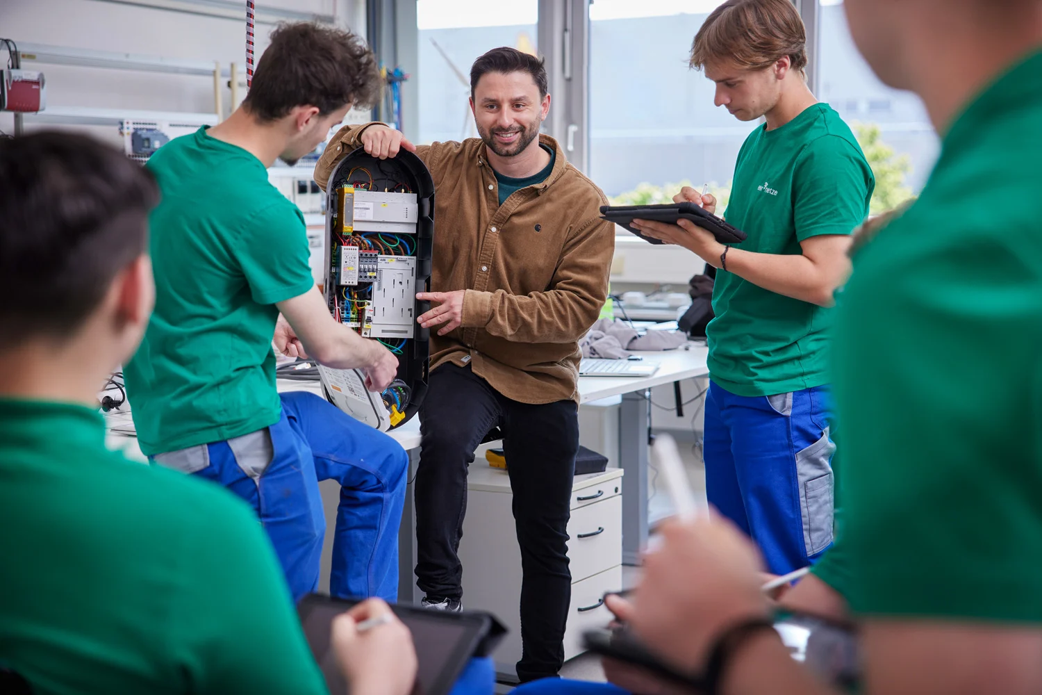 Technische Azubis bekommen in der Lehrwerkstatt etwas erklärt