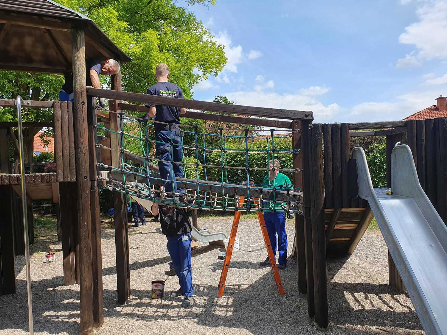 Helferinnen und Helfer verleihen dem großen Klettergerüst in Wallertheim einen neuen Anstrich.