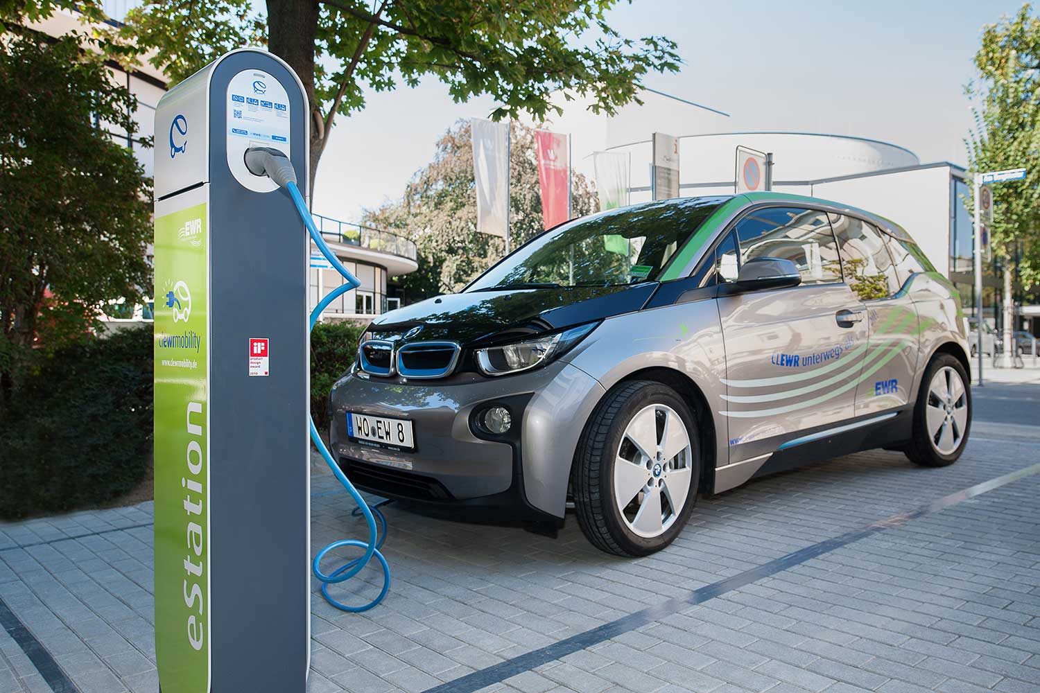 BMW Elektroauto steht an Ladestation auf einem Parkplatz BMW Elektroauto steht an Ladestation auf einem Parkplatz