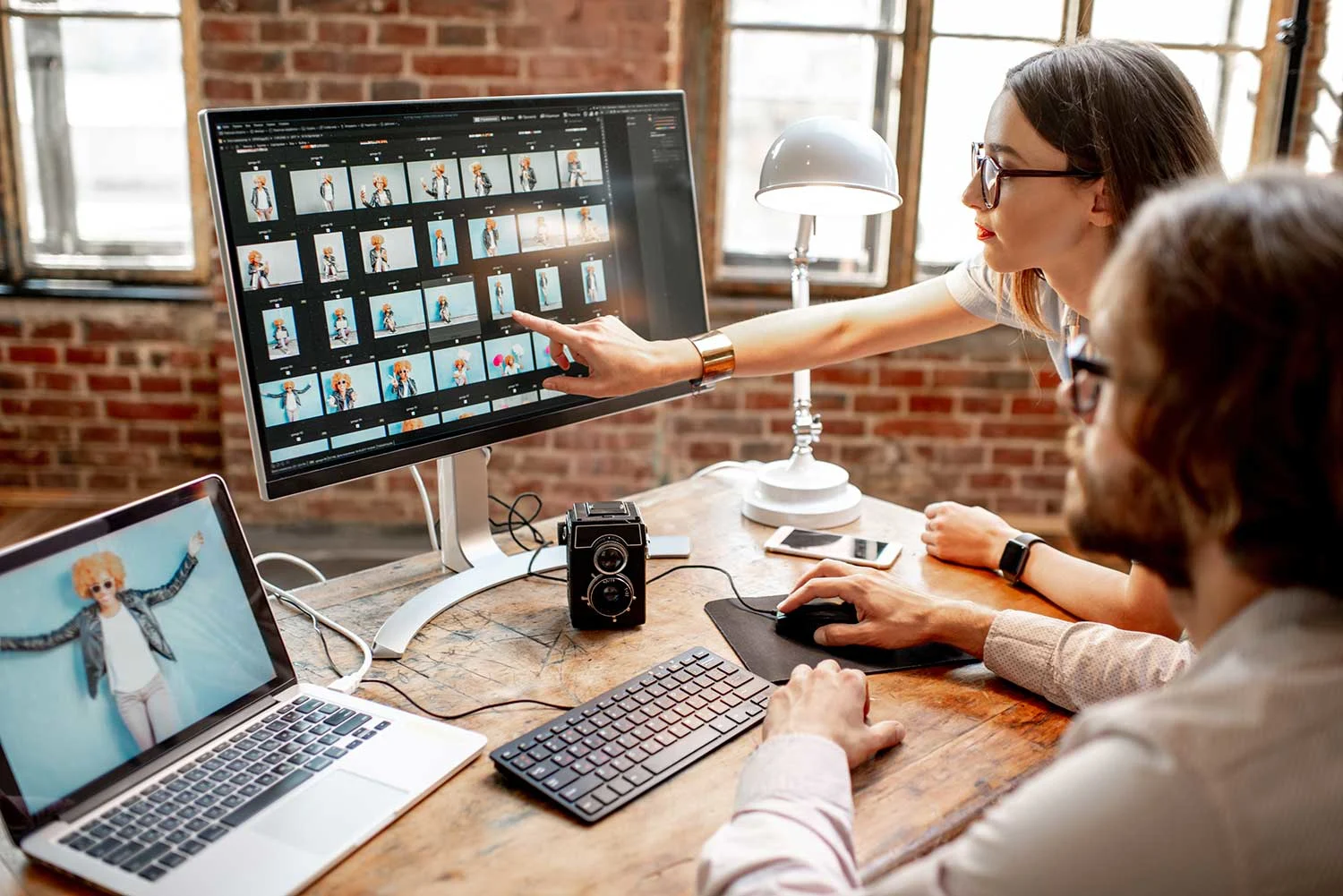 Zwei Personen, die auf dem Computer Bilder bearbeiten