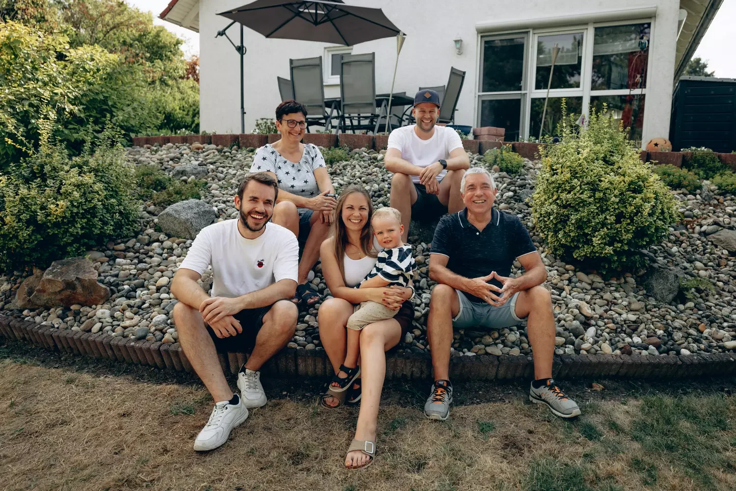 Familie Krause sitzend vor Haus.