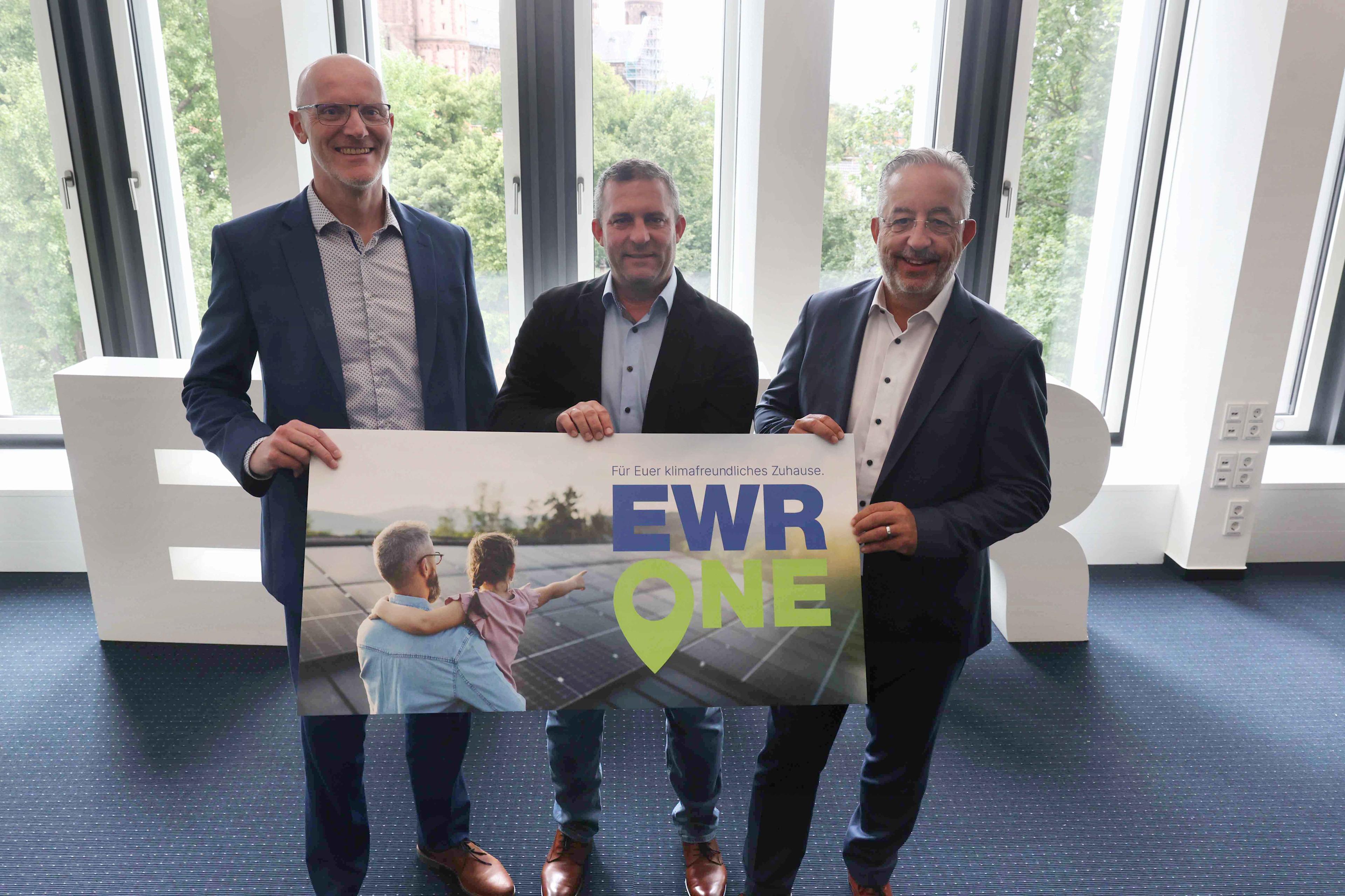 Titelbild Dieter Lagois, Ronnie Schrinner und Stephan Wilhelm halten gemeinsam ein Schild, auf dem EWR One steht.