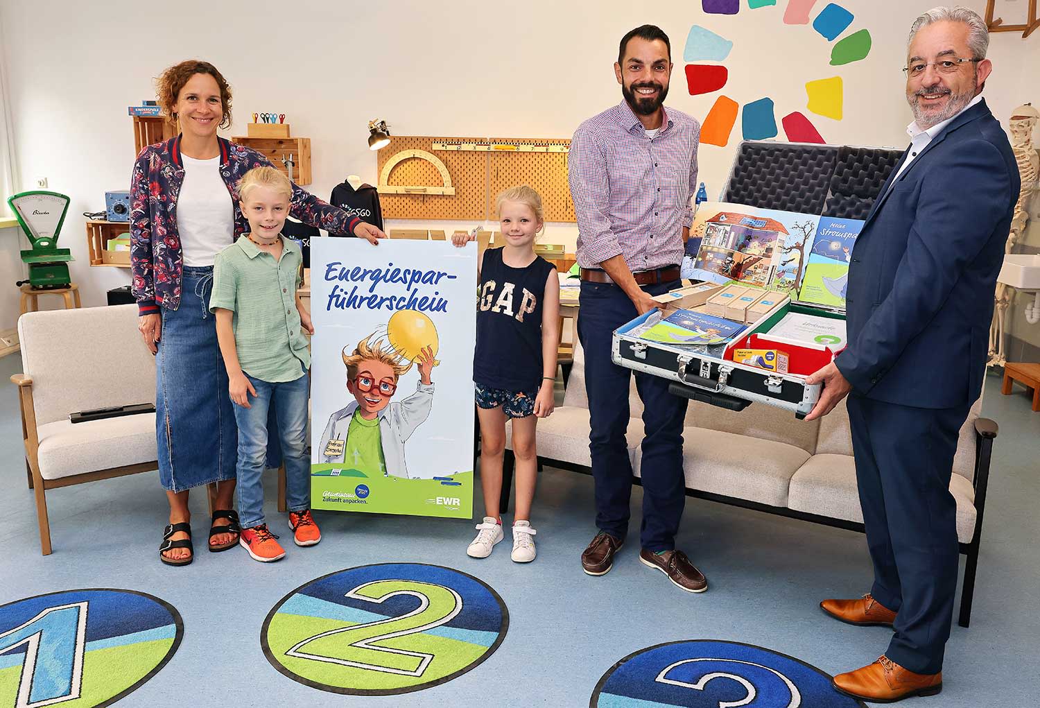 Titelbild EWR Vorstand und Pressesprecher stellen den Energiesparführerschein einer Grundschullehrerin vor.