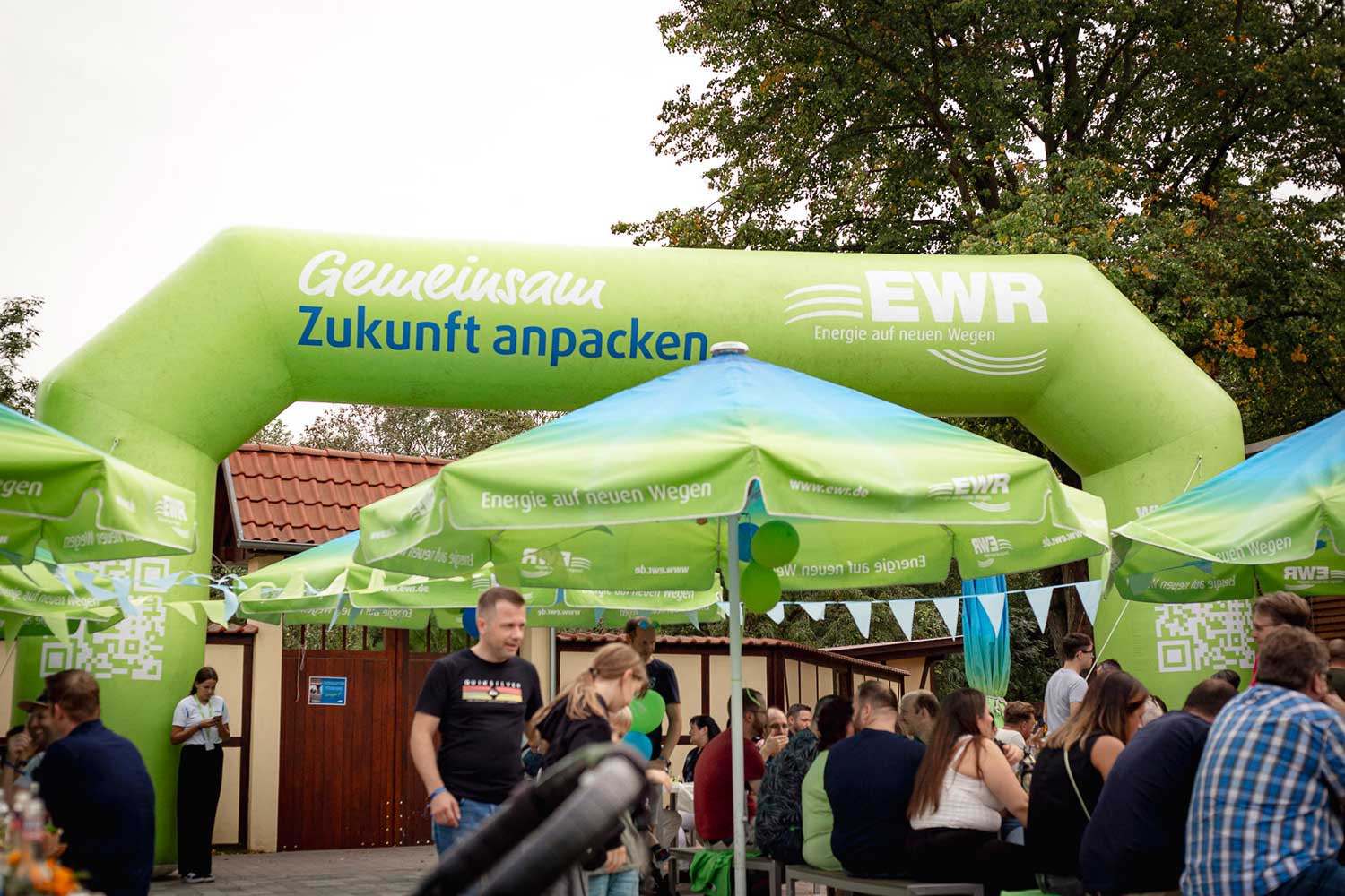 Grüne EWR Sonnenschirme und ein aufblasbares Tor auf dem Gemeinsam Zukunft anpacken steht